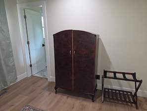 Ein Zimmer mit einem Holzkasten, einer Bank und einer Tür zu einem weiteren Raum.
