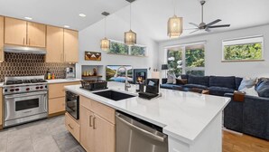 A modern kitchen with a central island, stainless steel appliances, and pendant lighting. - Eagle Vail Mountain Retreat w/Fenced Yard (Avon)