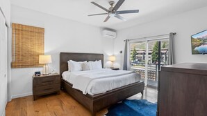 A bedroom with a bed, bedside tables, a ceiling fan, a large window, and a view of the outside. - Eagle Vail Mountain Retreat w/Fenced Yard (Avon)
