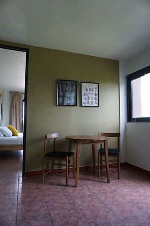 Une pièce comprenant un lit, deux chaises, une table et deux tableaux encadrés accrochés au mur.