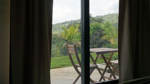 A room with a large sliding glass door leading to an outdoor area with a wooden table and chairs.