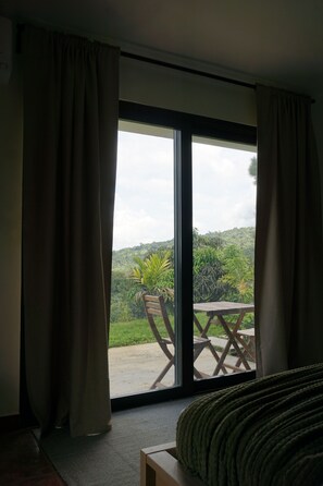 A room with a large sliding glass door leading to an outdoor area with a wooden table and chairs.