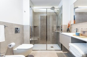 A modern bathroom with a glass shower enclosure, a toilet, a sink, and a mirror. - CO99 - URBAN APARTMENT (Milano)
