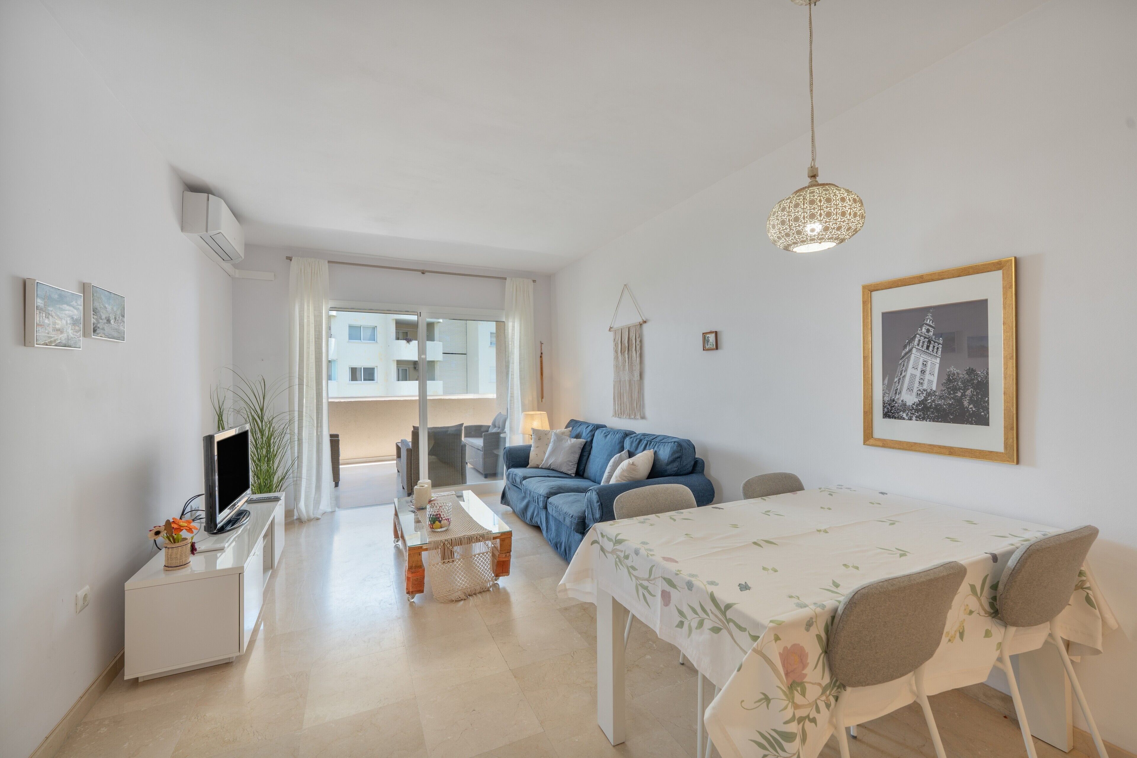 Een moderne woonkamer met een bank, een eettafel en een televisie.