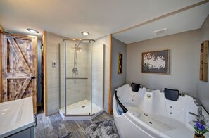 Ein modernes Badezimmer mit einer gläsernen Duschkabine, einer großzügigen freistehenden Badewanne und einem spiegel mit Holzrahmen.