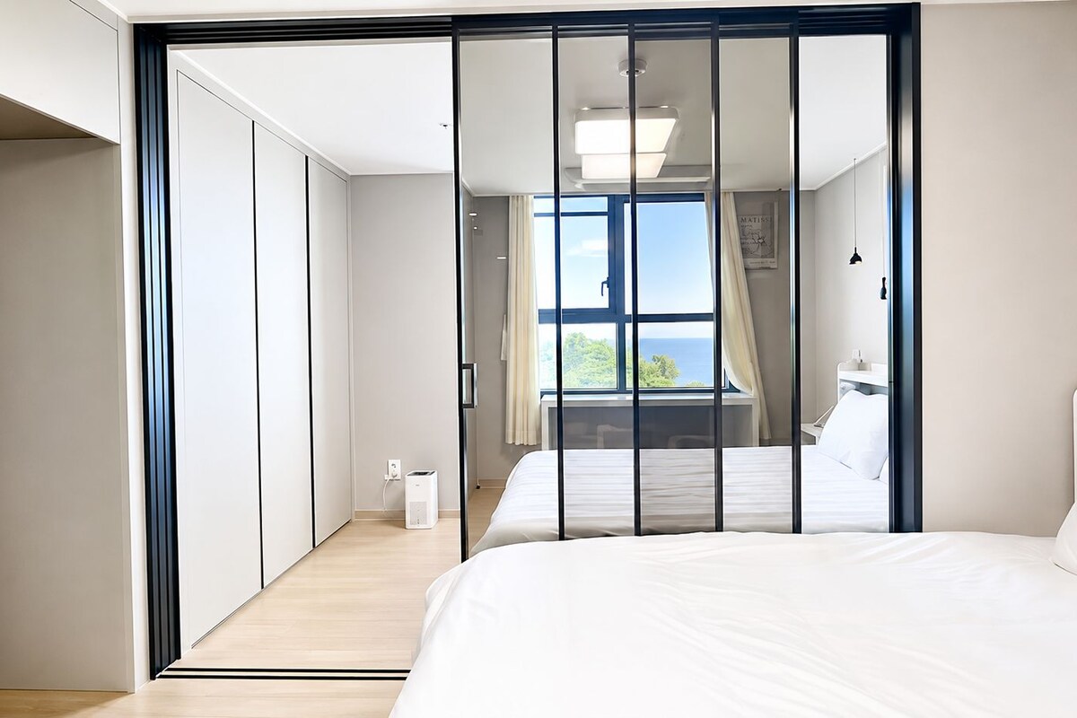 Un dormitorio con cama, armario y vistas al exterior.