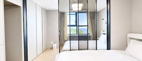 Un dormitorio con cama, armario y vistas al exterior.