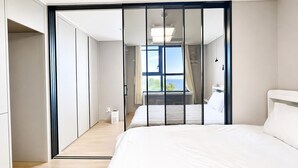 Un dormitorio con cama, armario y vistas al exterior.