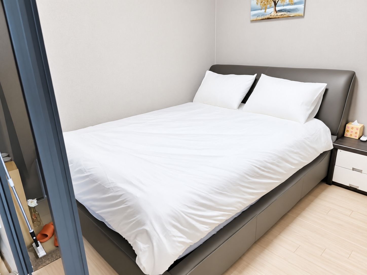 A neatly made bed with white linens in a modern hotel room.