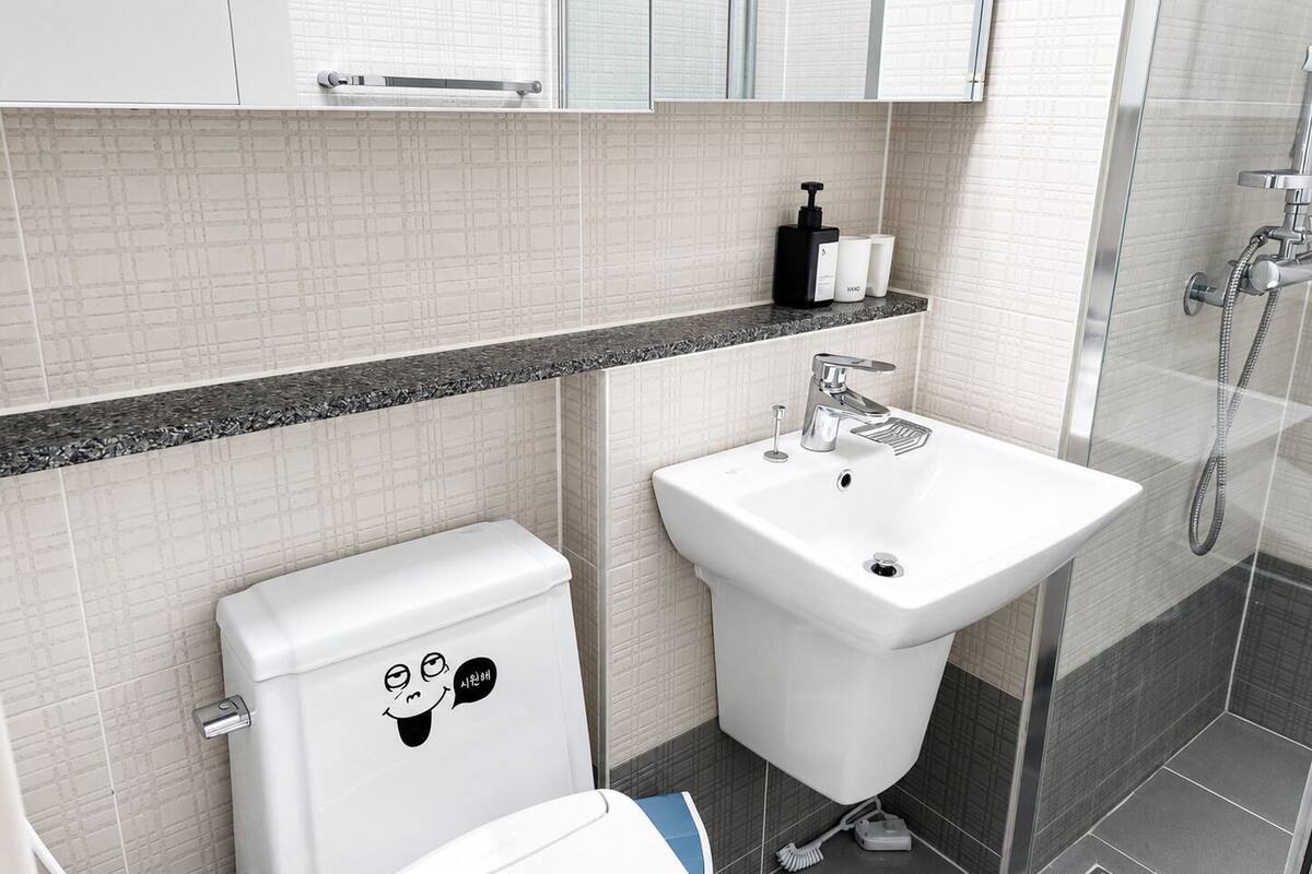 Ein modernes Badezimmer mit Toilette, Waschbecken und Dusche.