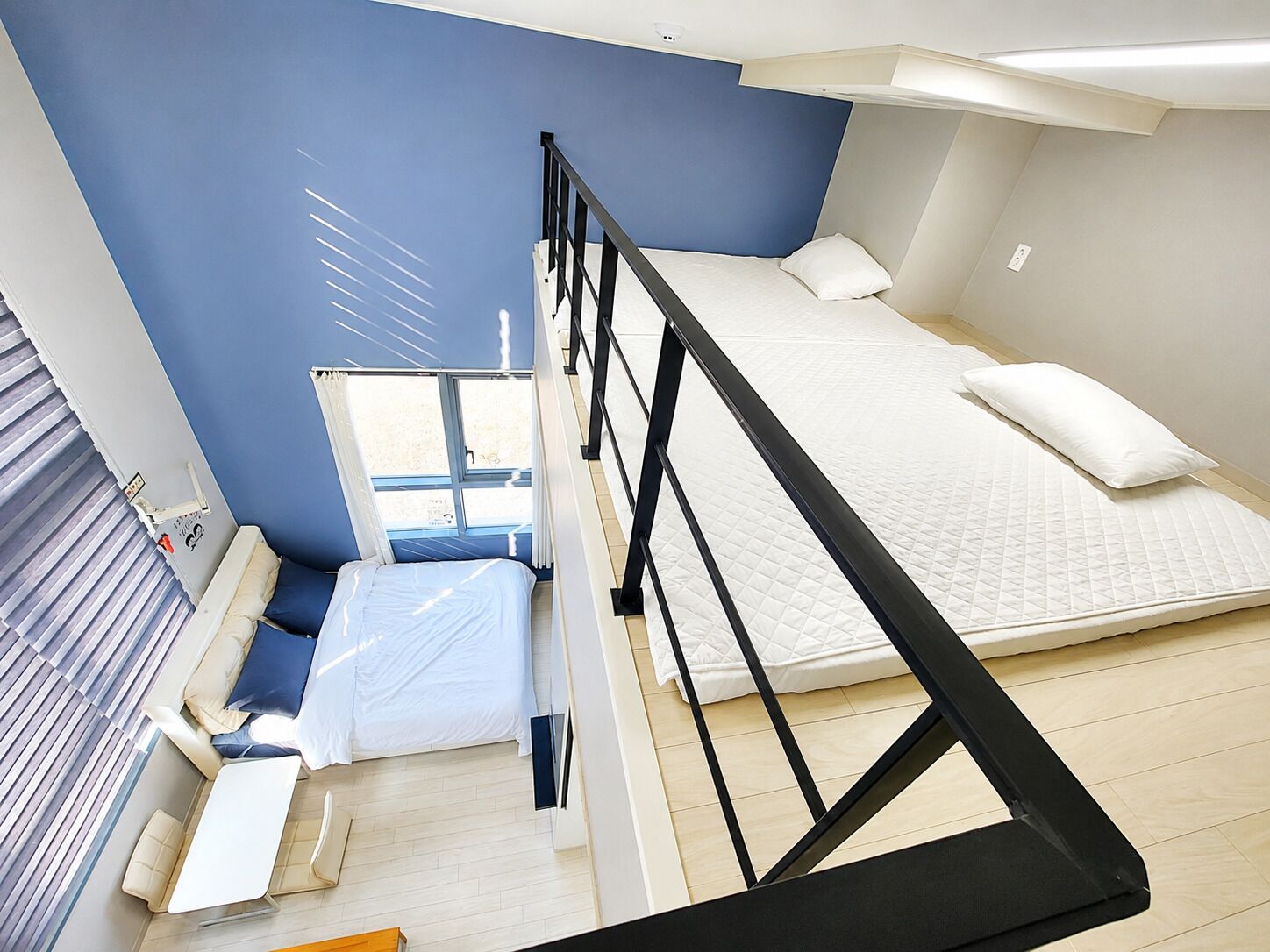 Un dormitorio moderno con una cama nido, un escritorio y una ventana.