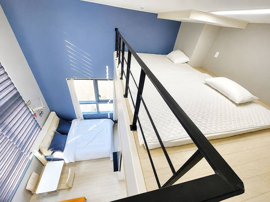 Un dormitorio moderno con una cama nido, un escritorio y una ventana.
