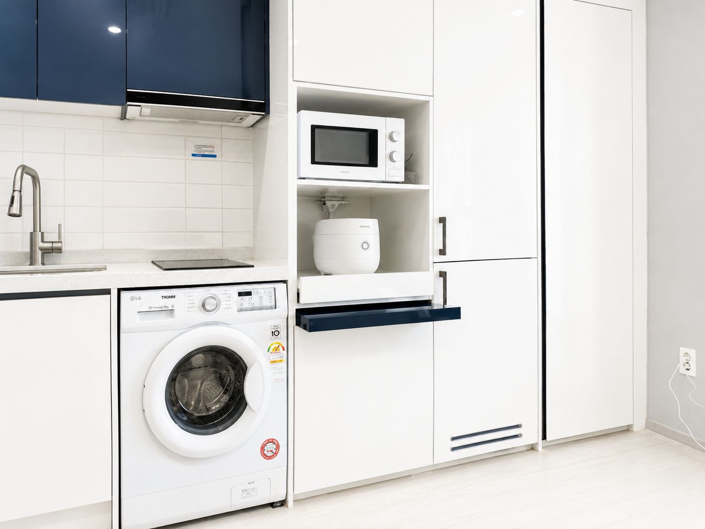 Cocina compacta con lavadora, microondas y horno empotrado.