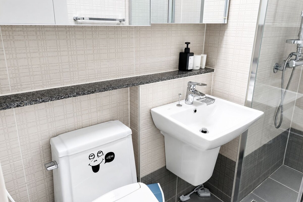 Un baño moderno con inodoro, lavamanos y ducha.