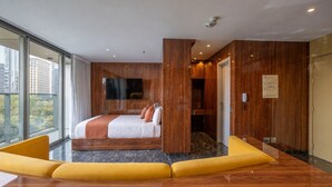 Une chambre d’hôtel moderne dotée d’un grand lit, d’un téléviseur à écran plat et offrant une vue sur la ville.