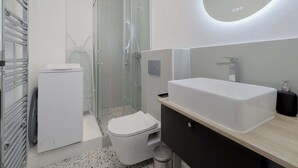 A modern bathroom with a toilet, sink, and shower. - Spacious apartment 8PAX in the center (Paris)