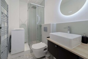 Ein modernes Badezimmer mit Toilette, Waschbecken und Dusche.