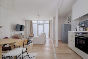 A modern apartment with a dining area, a living room, a kitchen, and large windows. - Spacious apartment 8PAX in the center (Paris)