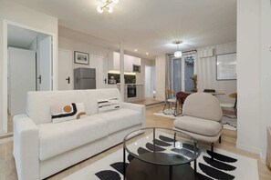 Ein modernes Wohnzimmer mit Sofa, Couchtisch und Essbereich.