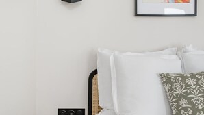 Ein schlichtes Badezimmer mit Toilette, Bidet und einem gerahmten Kunstwerk an der Wand.