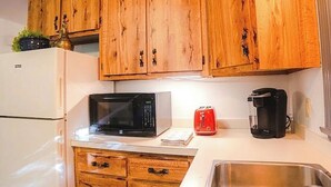 Eine Küche mit Holzausstattung, einer Mikrowelle, einem Toaster und einer Kaffeemaschine.