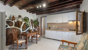 A kitchen with white cabinets, a wooden dining table, and chairs. - Charming Farmhouse Retreat in Arona With Stunning Views (Arona)
