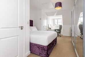A bedroom with a bed, a desk, a chair, and a large window. - Spacious 4-Bedroom Home in Moston with Free Parking, Garden & Fast WiFi (Manchester)