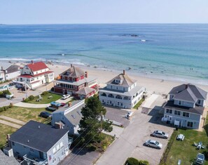 Ein Luftbild eines Küstenwohngebiets mit Häusern, einem Strand und blauem Himmel.
