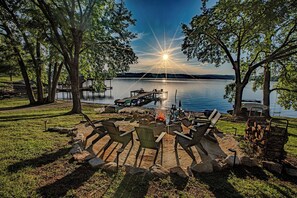 A lakeside outdoor seating area with chairs, a fire pit, and a dock. - Lakefront/Hot Tub/Sauna/Fire Pit (Ten Mile)
