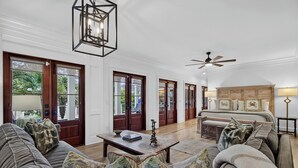 Un salon spacieux avec un grand canapé, une table basse et un ventilateur de plafond.