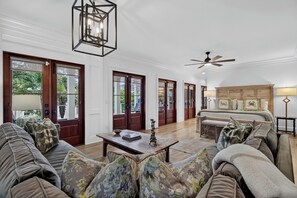 Ein geräumiges Wohnzimmer mit einem großen Sofa, einem Couchtisch und einem Deckenventilator.