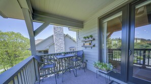 A balcony with a table and chairs, a potted plant, and a view of neighboring houses. - Camelia 4 | Fireplace, Restaurant, Pool, Spa (Blowing Rock)