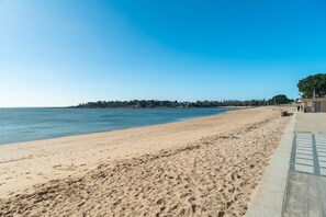 A beach with a clear sky, sandy shore, and a building with a pathway. - Apartment "Sea View" with Private Terrace, Balcony, and Wi-Fi (Bénodet)
