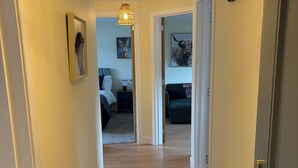 Un corridoio con un tappeto decorato, una lampada a sospensione e un termosifone.