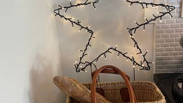 A woven basket with a baguette and a star-shaped light decoration.