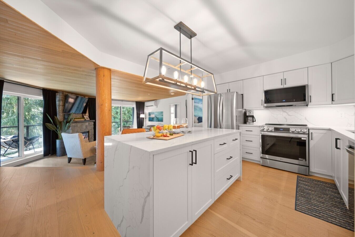 Una cucina moderna con isola in marmo, elettrodomestici in acciaio inossidabile e un'ampia finestra con vista sul verde.