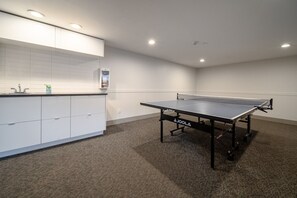 A room with a ping pong table, white cabinets, and a small kitchenette area. - Whistler Retreat with Pool/Hot Tub Free Parking (Whistler)