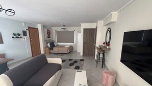 Una sala de estar con sofá, mesa de centro, televisor y un comedor con sillas y una mesa.