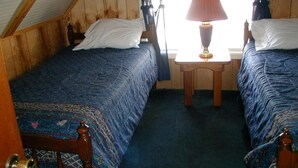 Een kamer met twee bedden, een kleine tafel en een raam.