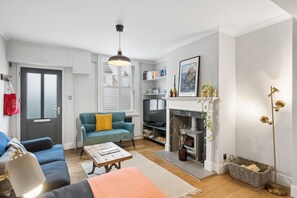 Ein Wohnzimmer mit Sofa, Couchtisch, Kamin und Bücherregal.