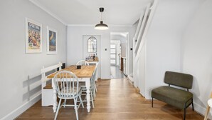 Un'area pranzo con un tavolo e sedie in legno, una lampada a sospensione e una panca.