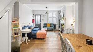 Un appartamento moderno con un'area pranzo, un divano, un tavolino e una libreria.