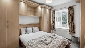 Una camera da letto con un letto, un armadio in legno e una finestra con tende.