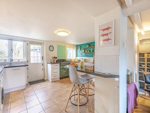 A kitchen with a dining area, a green oven, and a window with blinds. - Beautiful Country 3 Bed Escape, Warwickshire - Pass the Keys (Ufton)
