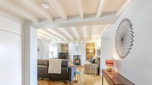 Una sala de estar moderna con chimenea, sofás y piso de madera.