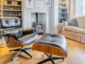 A modern living room with a sofa, two leather chairs, a wooden ottoman, a fireplace, and shelves with decorative items. - Beautiful Country 3 Bed Escape, Warwickshire - Pass the Keys (Ufton)