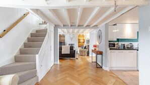 Un interior moderno con una escalera, una sala de estar y una cocina.