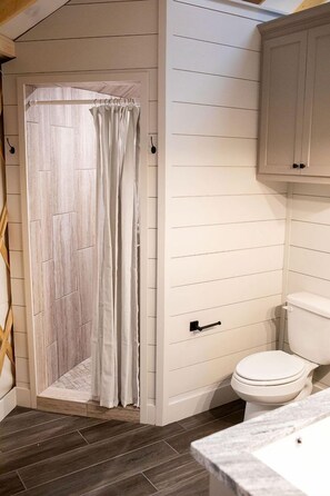 A bathroom with a shower, toilet, and a sink.
