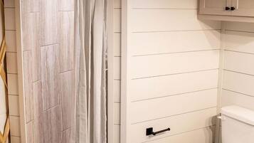 A bathroom with a shower, toilet, and a sink.