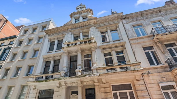 A historic building with classical architecture, multiple windows, and a prominent entrance. - Grand Ostend townhouse with sauna near the sea (Oostende)